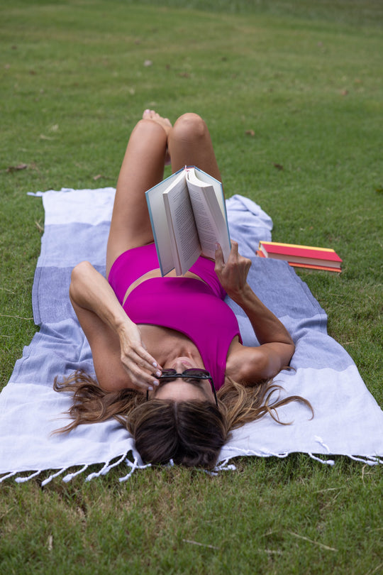 woman in a purple suit laying on grey, black and light grey turkish cotton towel showcasing the multi-gray towel.